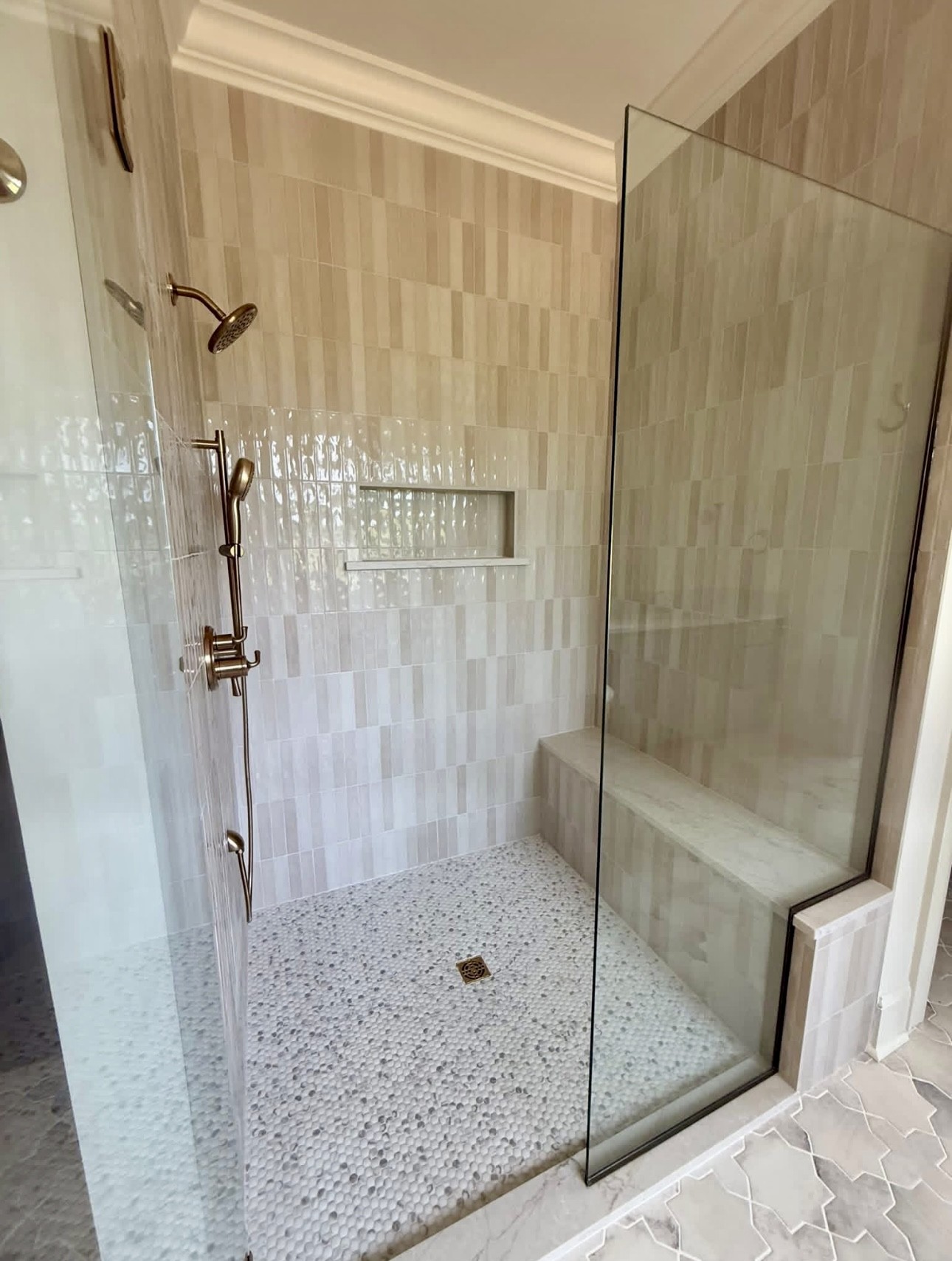 Cream tile shower with glass panel and bronze fixtures, Homewood, by CB Built Homes