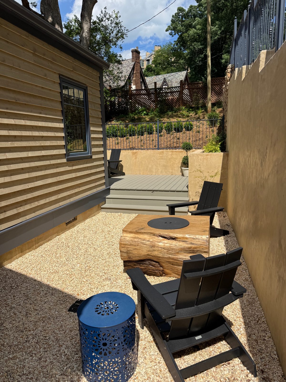 Landscaped patio with Adirondack chairs beside a custom home