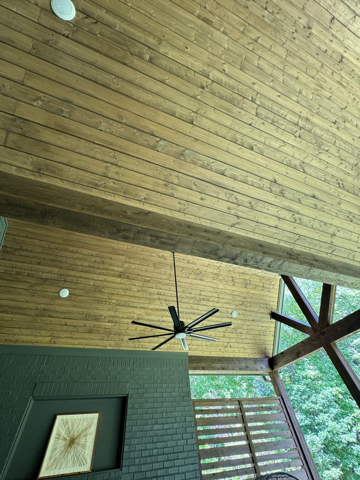 Covered porch with a stained wood ceiling, ceiling fan, and screened walls