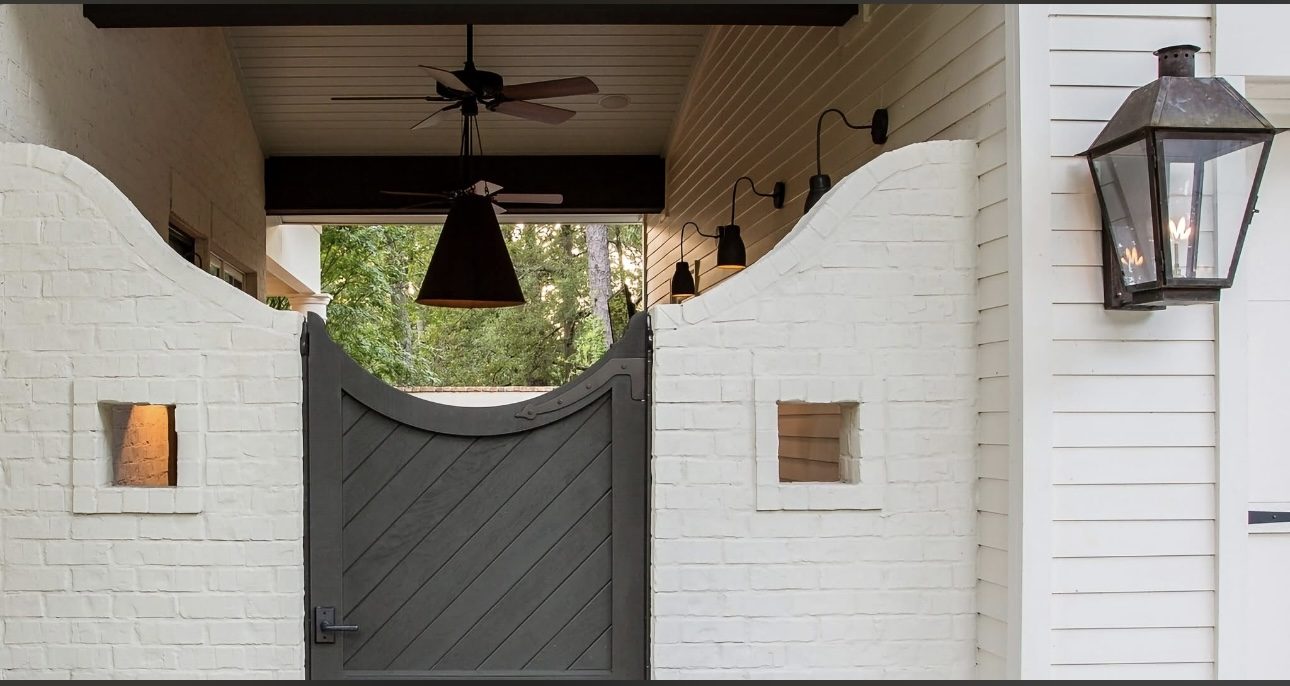 White painted exterior with a courtyard gate and lanterns