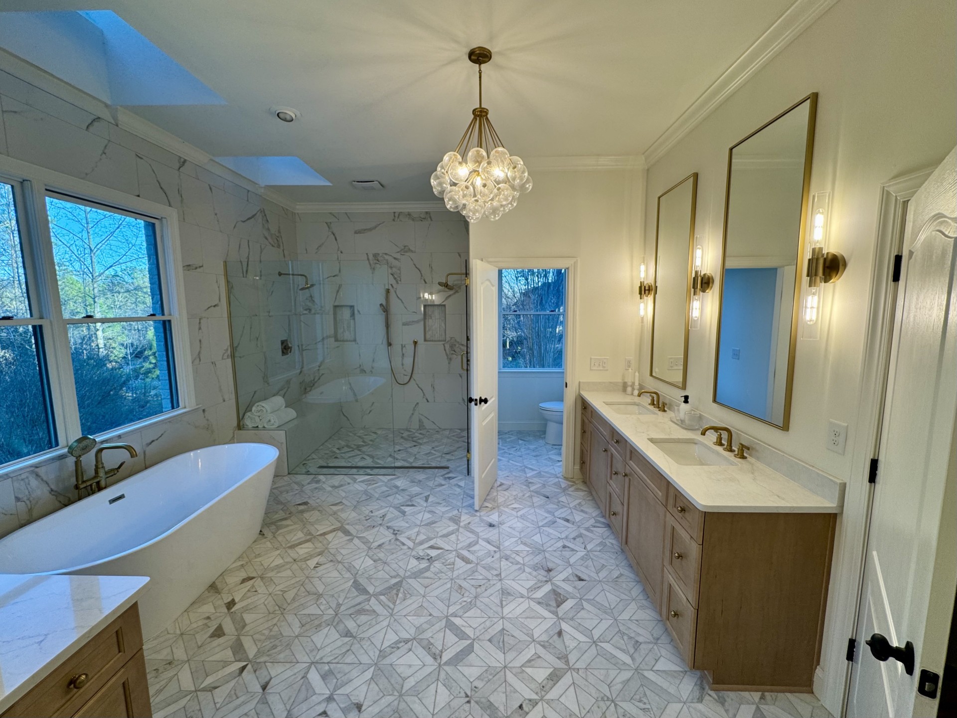 Large tiled bathroom with freestanding tub and wood double vanity, Mountain Brook, by CB Built Homes