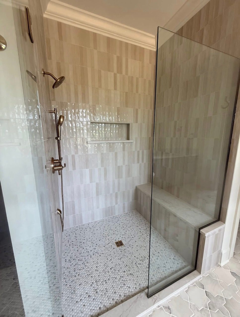 Tiled walk-in shower with a glass enclosure