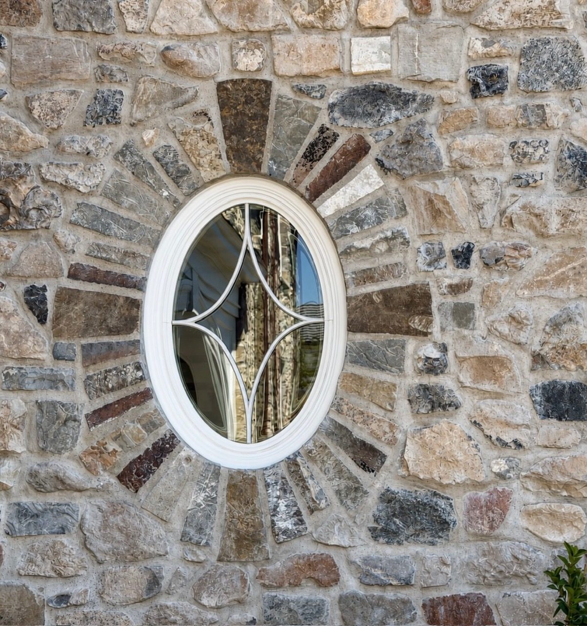 Custom stonework framing an oval accent window